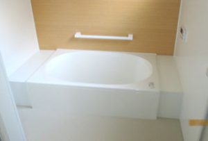 バスルーム【after】:床と壁はタイルの上から浴室パネルを貼り、費用を削減